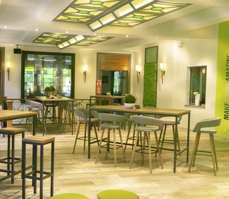 Empfanhsbereich im Hotel Das Ebertor mit Jugendstilfenstern an der Decke und begrünter Wand