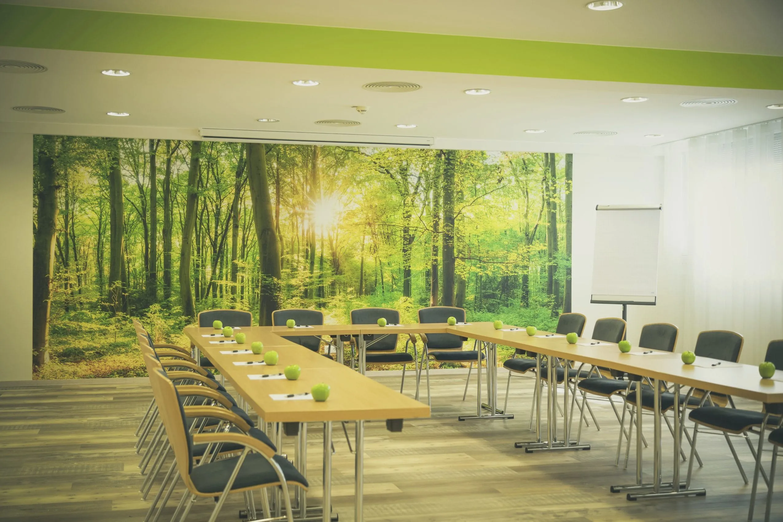 Tagungsraum im Hotel Das Ebertor mit Waldtapete und gr&uuml;nen &Auml;pfeln auf den Tischen
