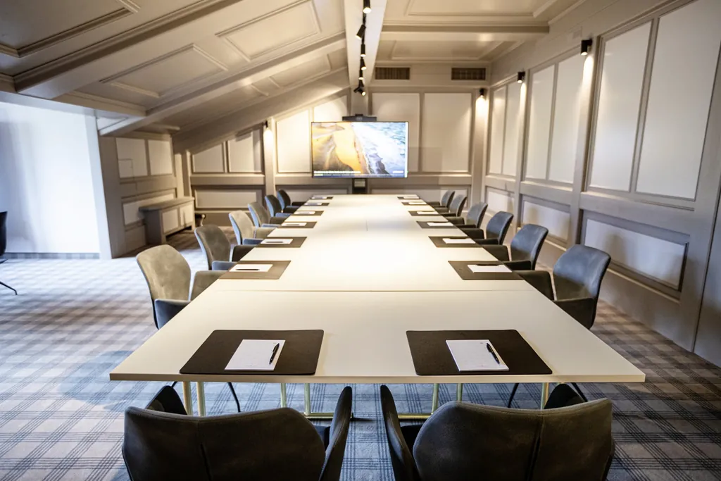 Tagungsraum unter der Dachschräge im Das König Ludwig Inspiration Spa mit grau gestrichener Vertäfelung