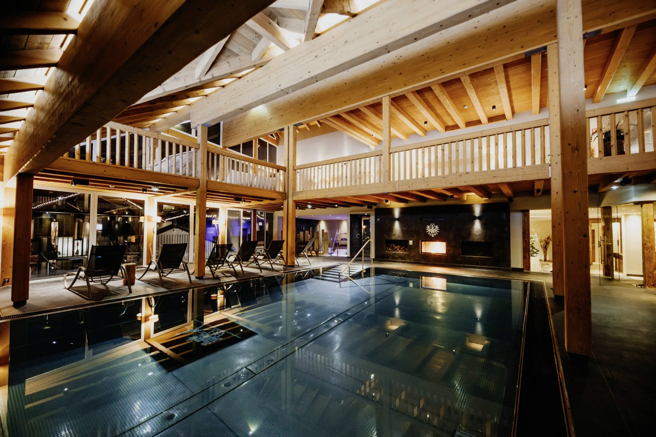 Indoorpool im Hotel Post Seefeld mit Holzgalerie am Abend