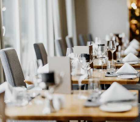 eingedeckte Tische im Restaurant des Hotel Post Seefeld mit grauen Hochlehnerstühlen