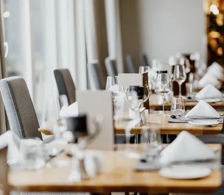 eingedeckte Tische im Restaurant des Hotel Post Seefeld mit grauen Hochlehnerstühlen