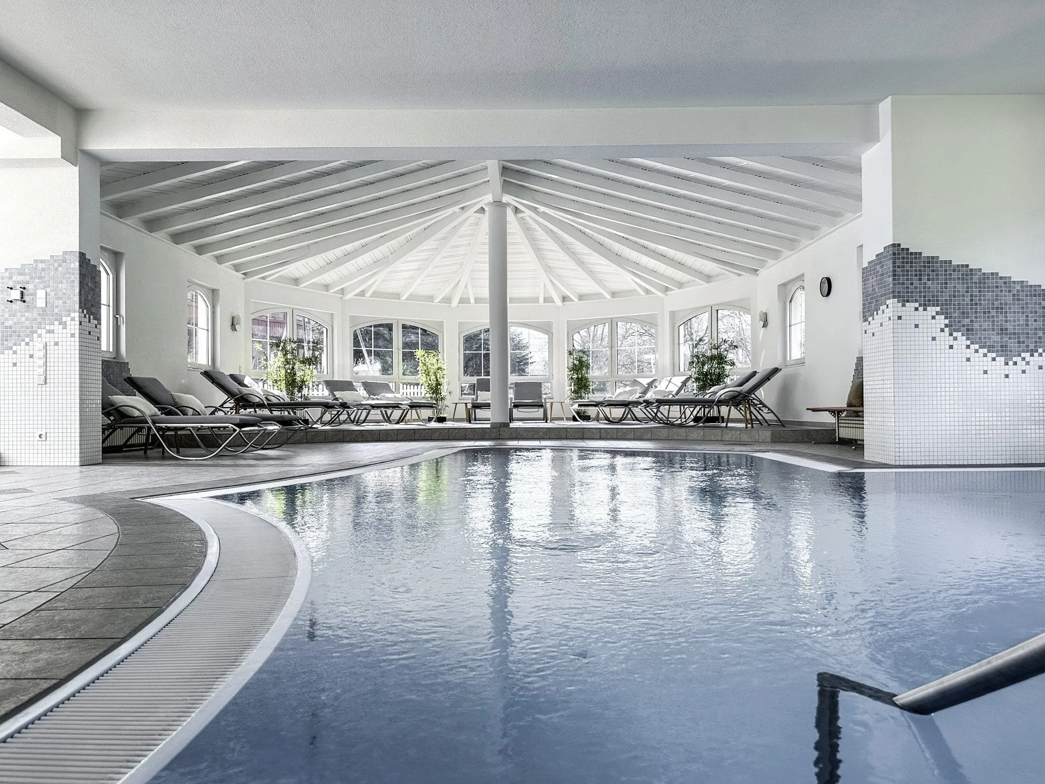 Indoorpool des Wellnesshotels Badischer Hof mit grauen Liegen