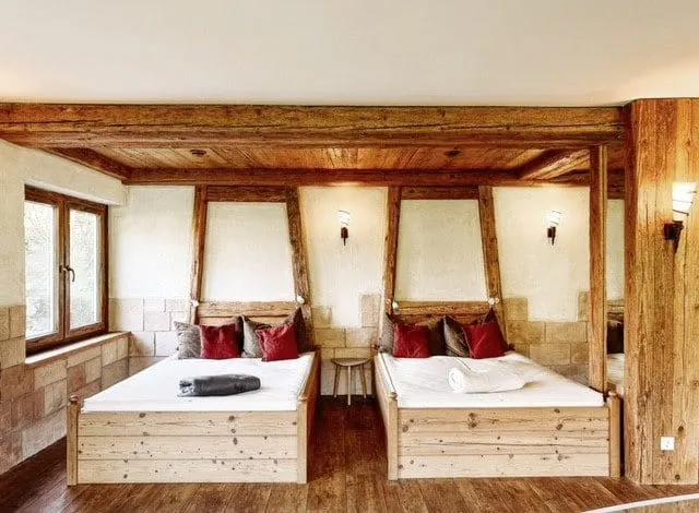 Wasserbetten im Ruheraum des Wellnessbereichs mit rustikalem Holzrahmen, kuscheligen Kissen und Decken.