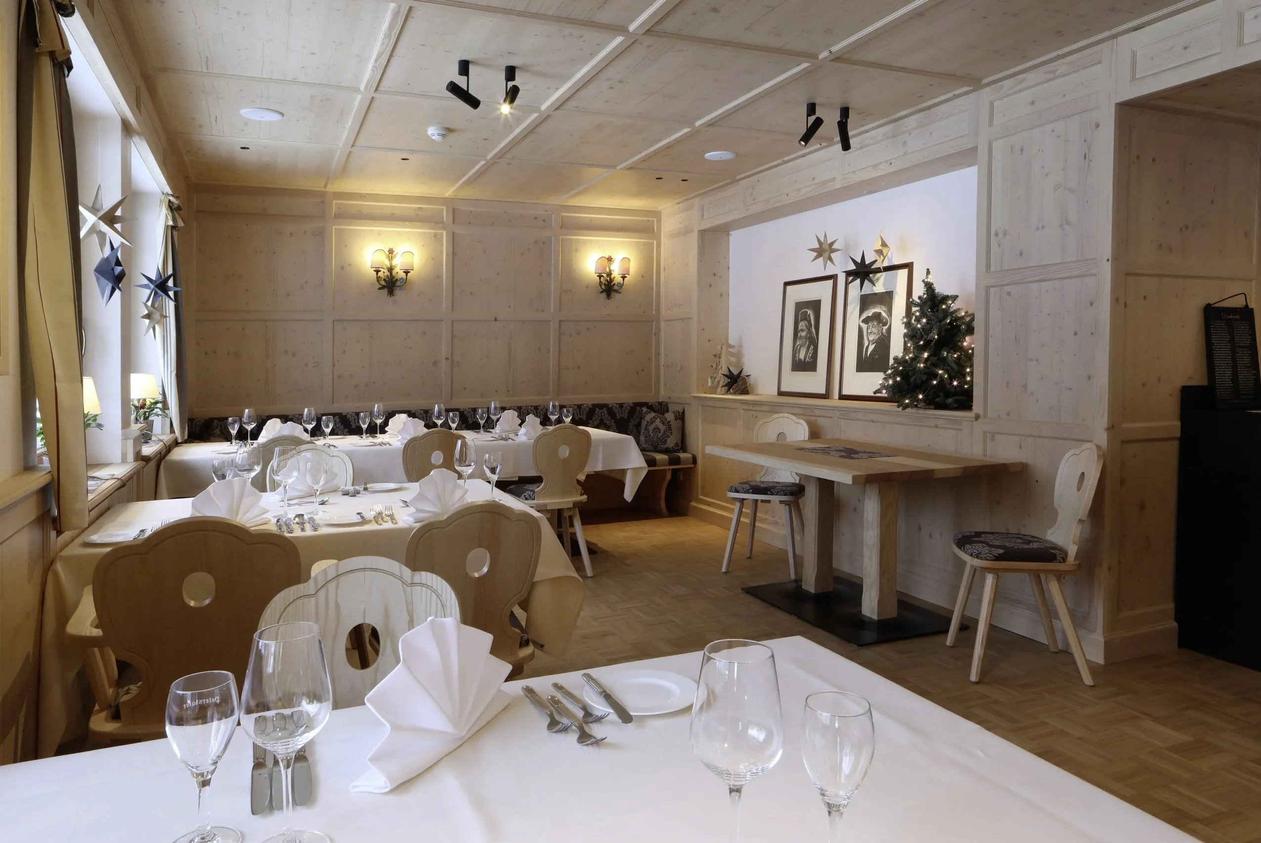 Urige Restaurantstube des Waldblick Hotel Kniebis mit Holzst&uuml;hlen, gedeckten Tischen mit wei&szlig;er Tischdecke und Holzw&auml;nden