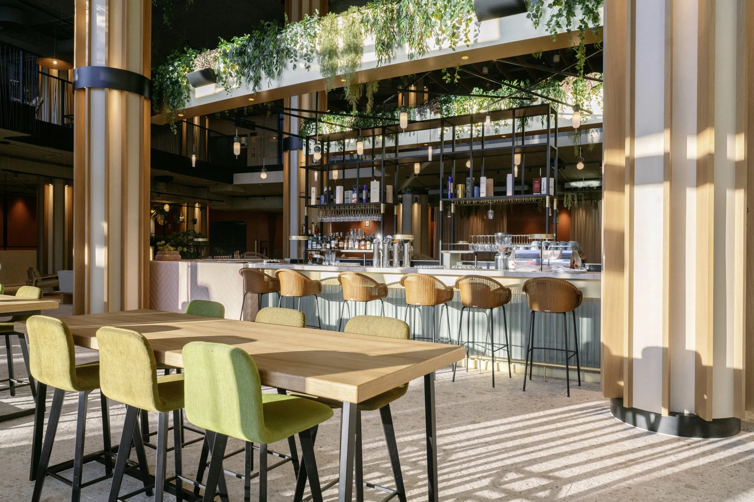 stylische Bar mit H&auml;ngepflanzen und Korb-Hochsesseln im A-ROSA Gardasee