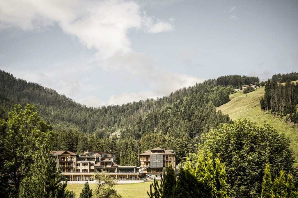 Gesamtansicht des Excelsior Dolomites Life Resort eingebettet in die Wiesen des Eggentals