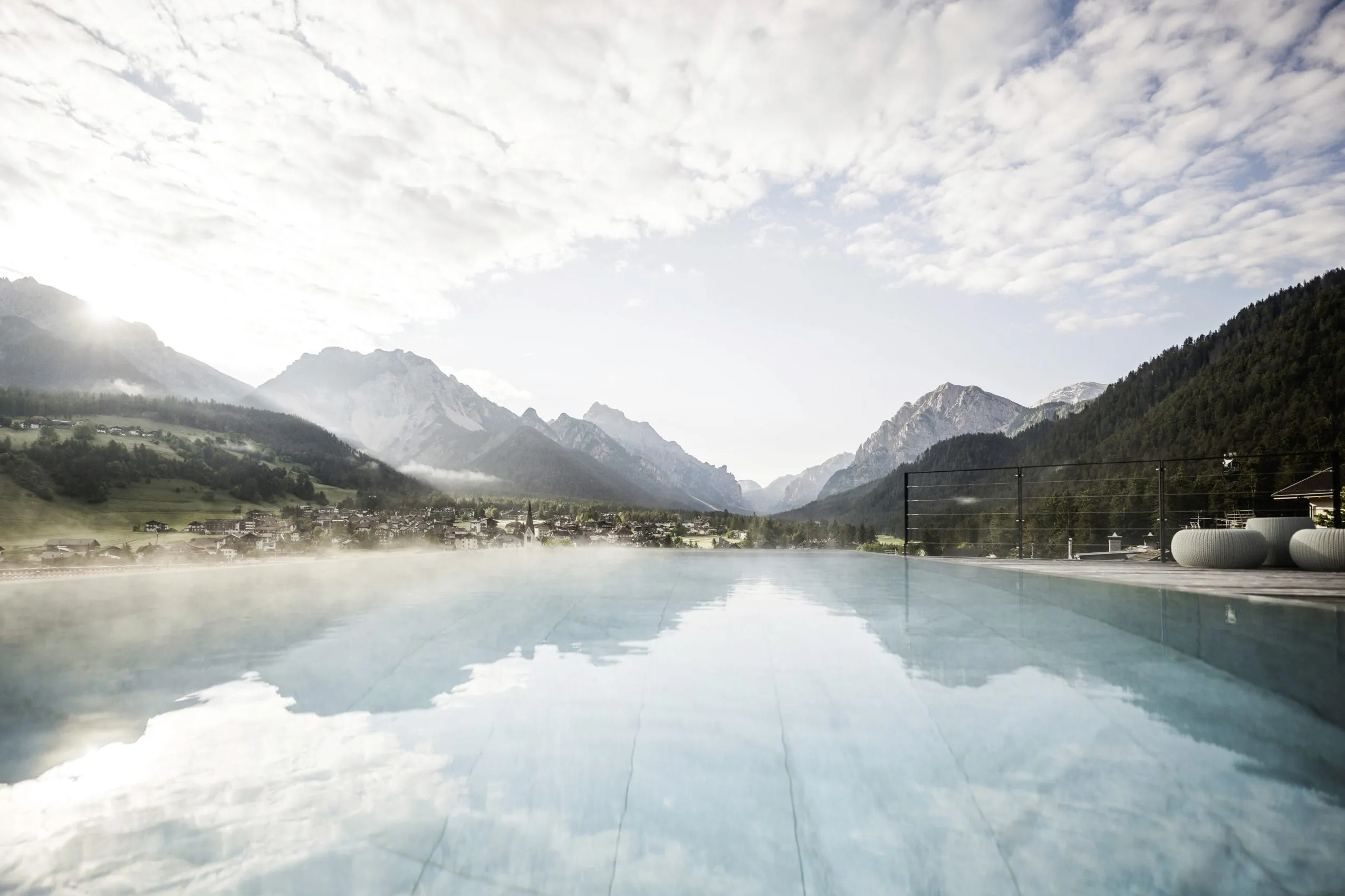 Ausblick vom Skypool des Excelsior Dolomites Life Resort auf die verschneiten Dolomiten