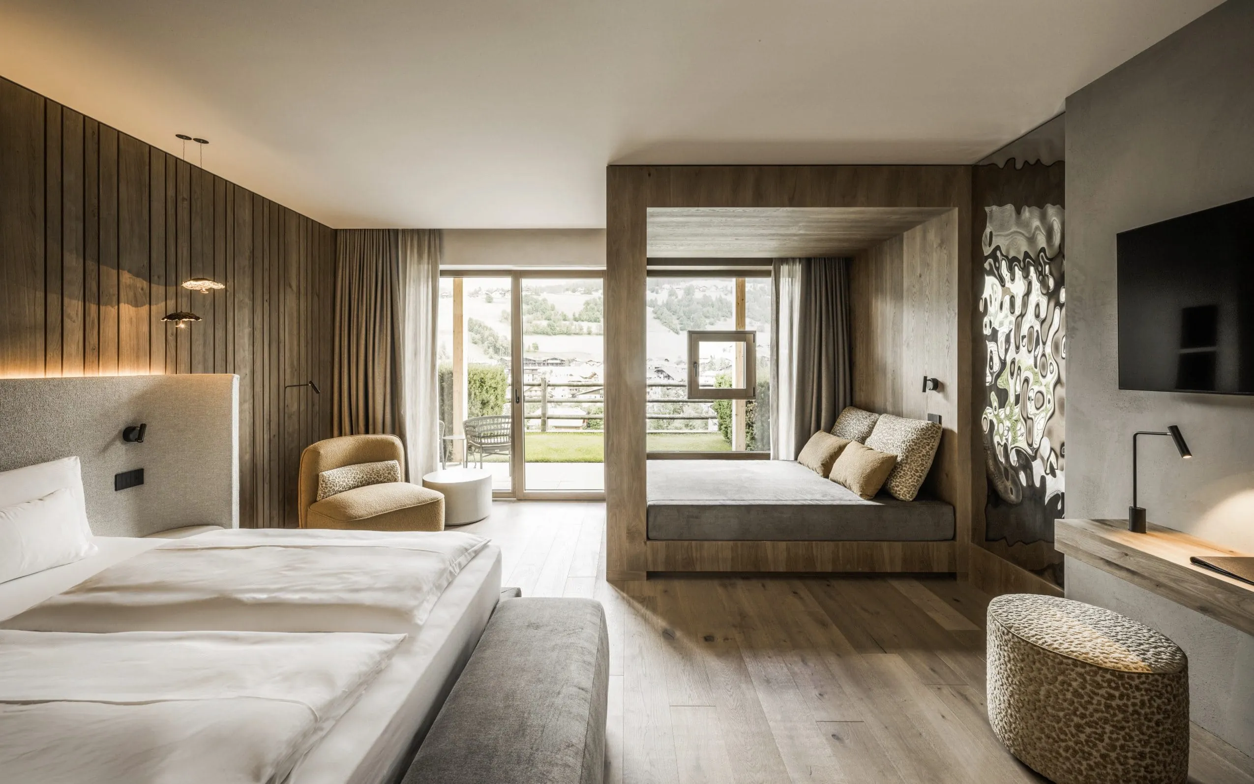 Suite im Excelsior Dolomites Life Resort mit Holz-Schlafkoje und getigertem Hocker