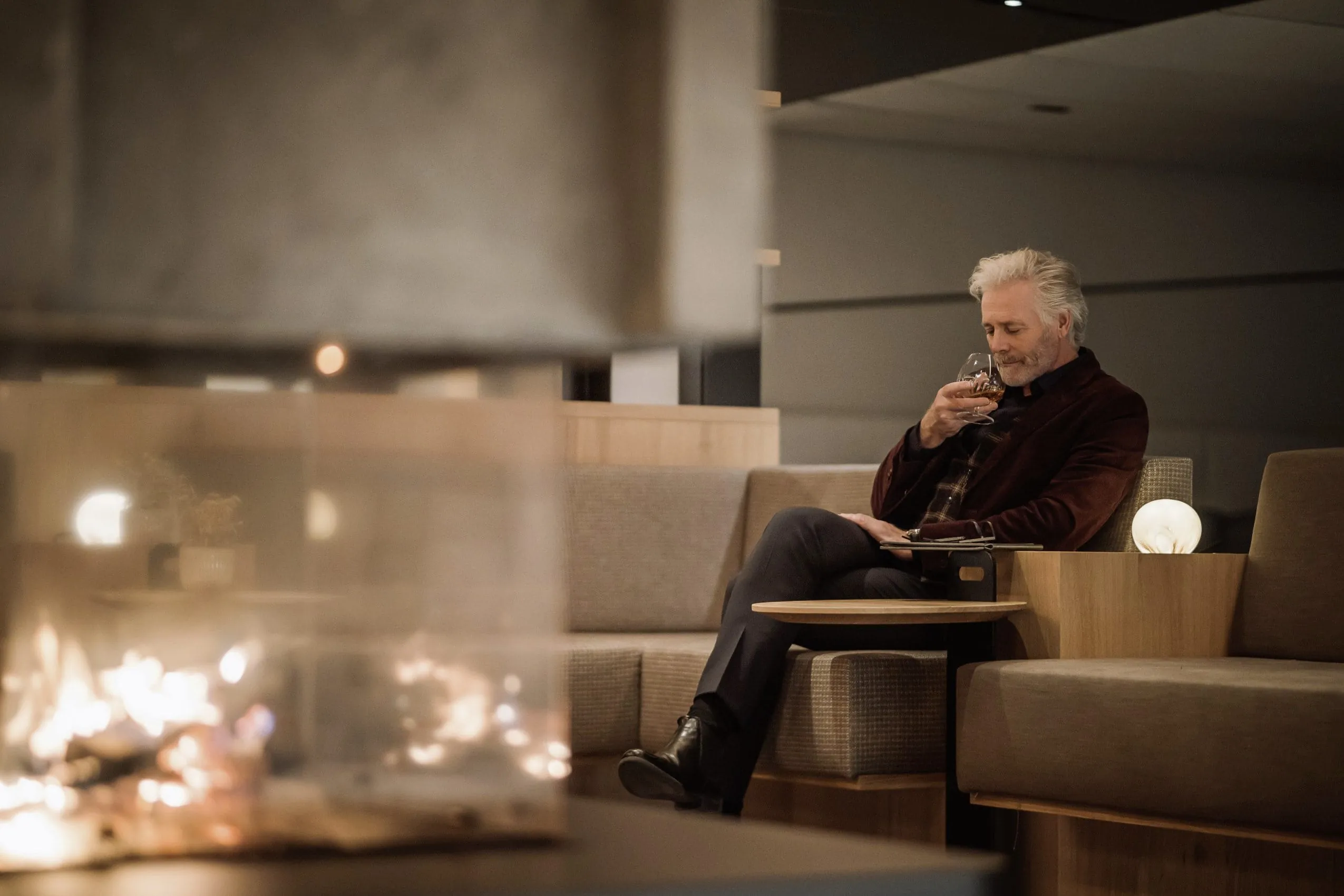 weißhaariger Mann sitzt mit Cognacglas in der Bar des Hotel Winkler