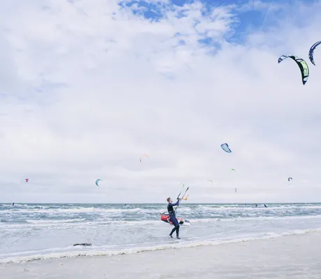 Mehrere Windsurfer am Strand des Beach Motel St. Peter-Ording