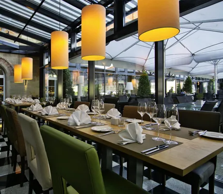 Wintergarten des Hundehotels nestor ludwigsburg mit prominenten, stilvollen Lampenschirmen für atmosphärische Beleuchtung.