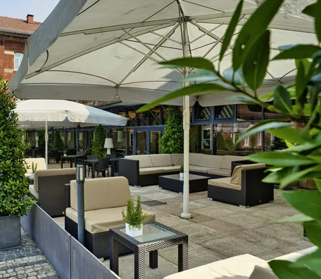 Lounge-Terrasse mit weißen Sonnenschirmen vor dem Hundehotel nestor Ludwigsburg