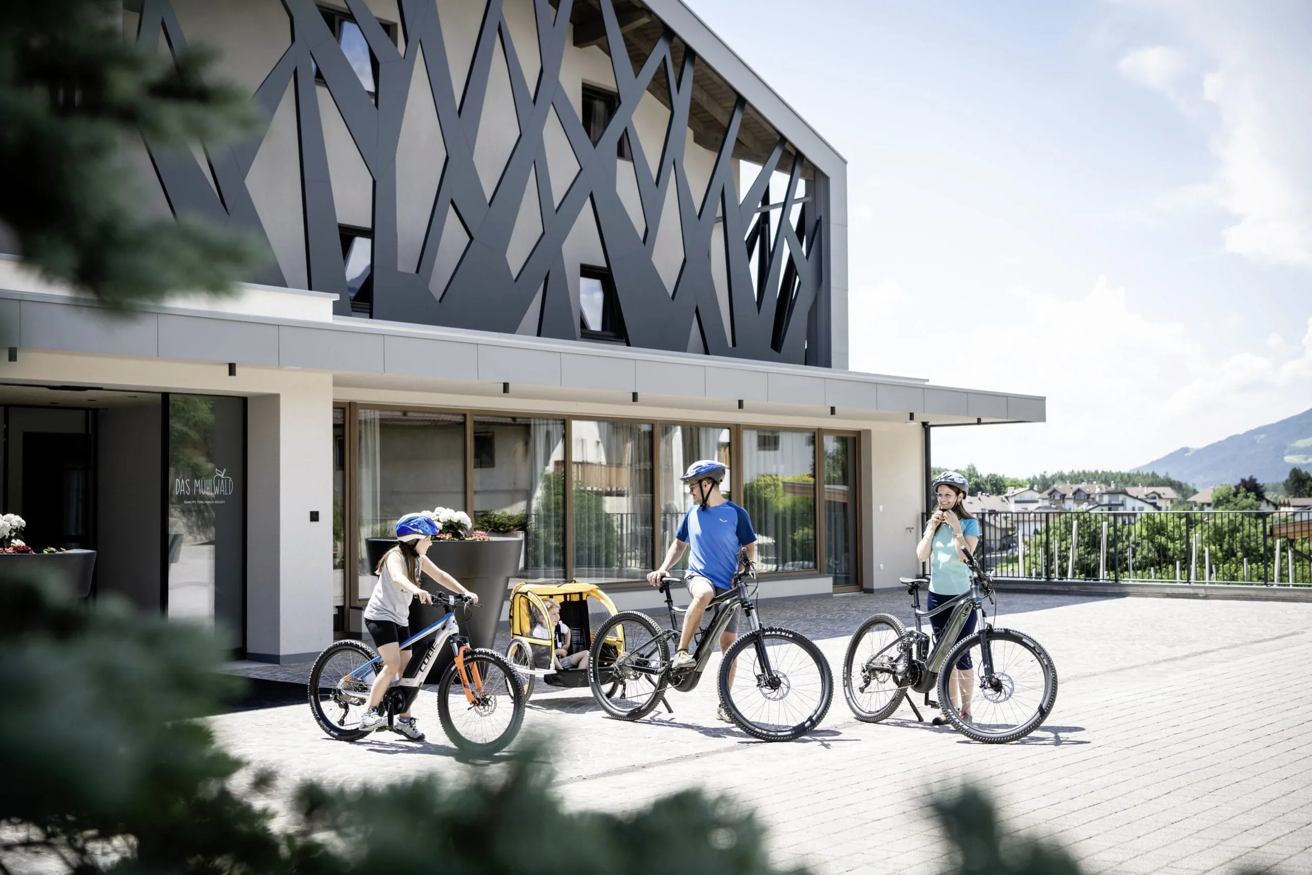 Familie macht sich vor dem Hotel Das Mühlwald für einen Bike-Ausflug fertig
