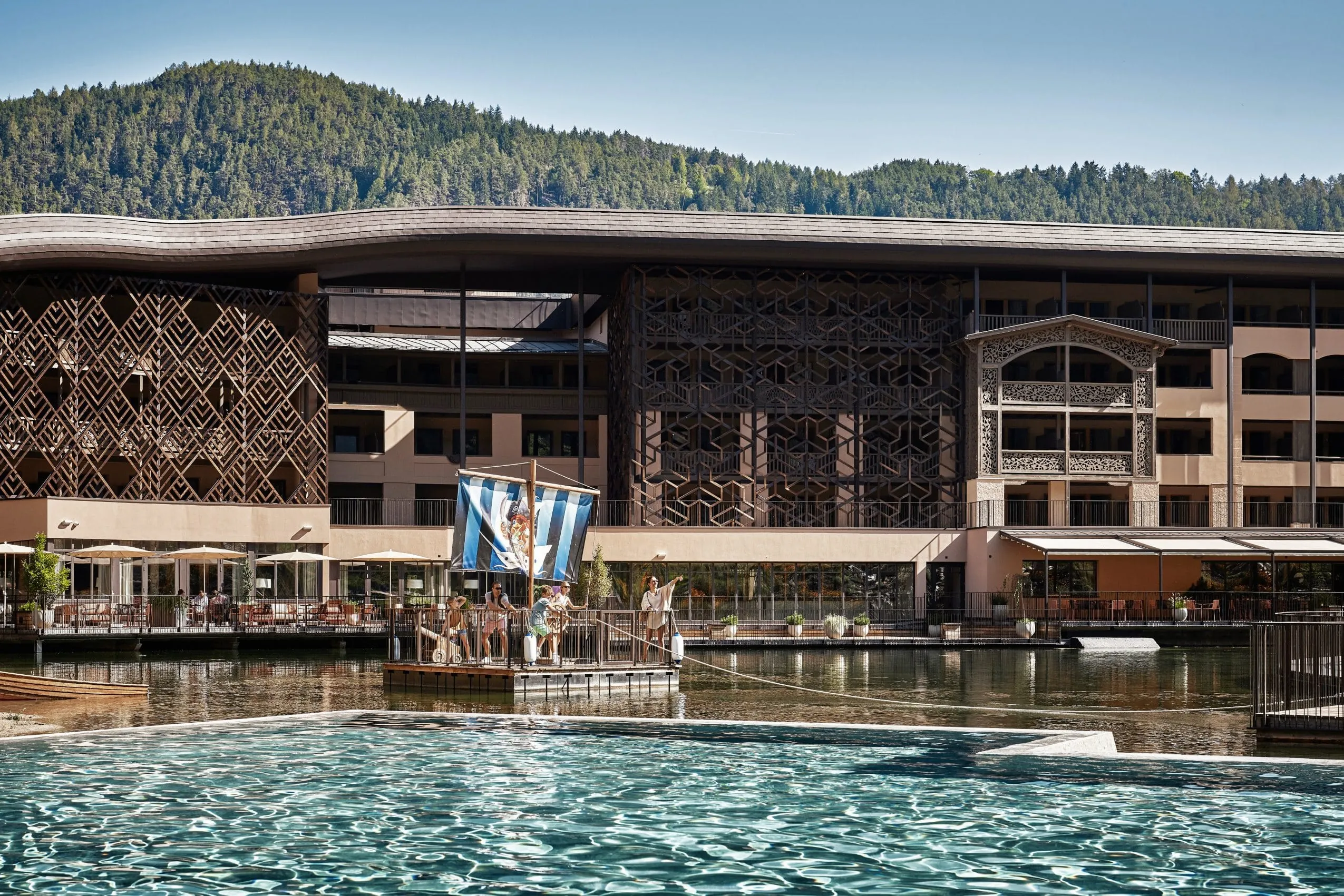Kinder auf einem Piratenfloß auf dem Teich vor dem Falkensteiner Family Resort Lido