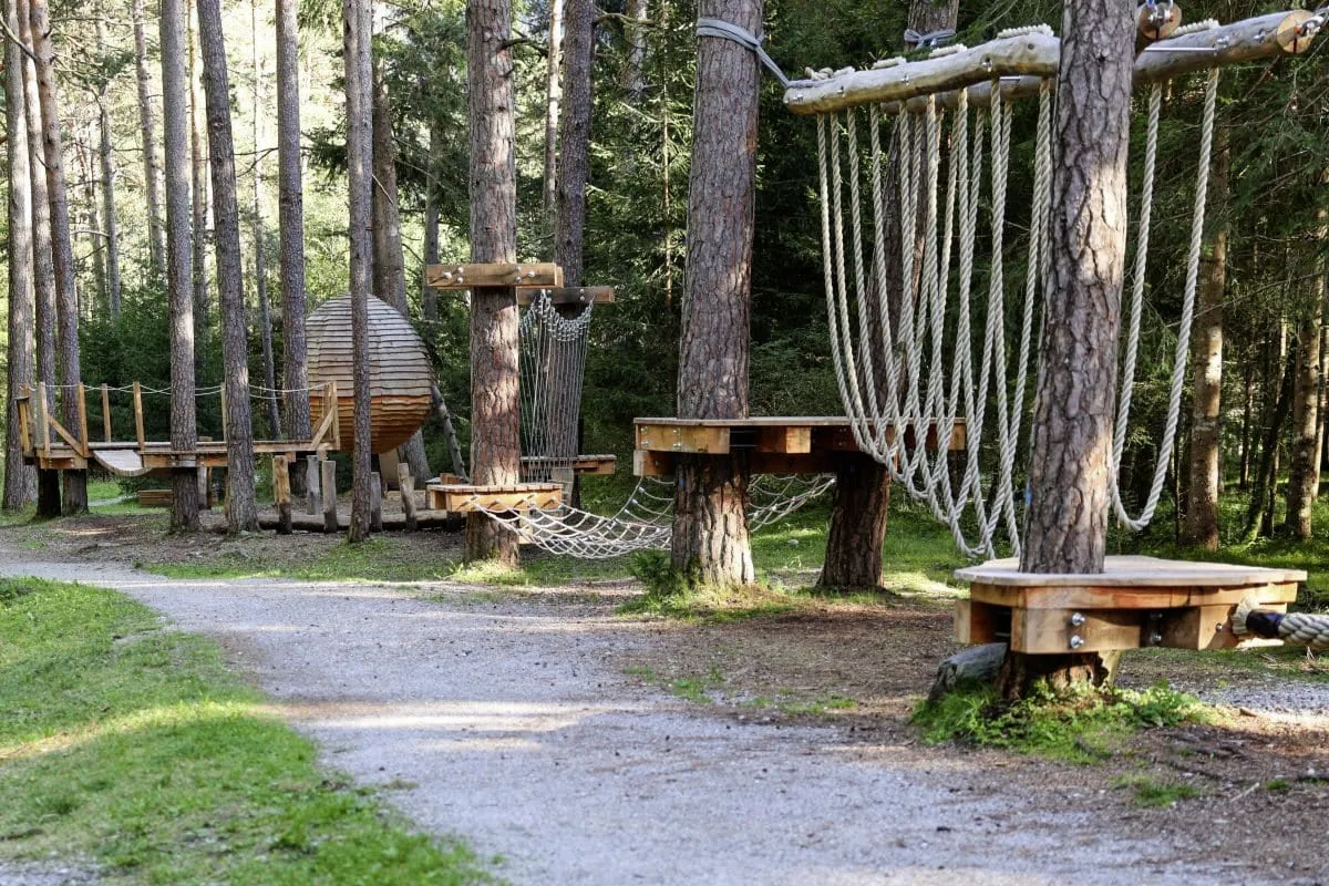 Waldspielplatz mit hängenden Seilen und Holz-Klettergerüsten im Hotel Alpin