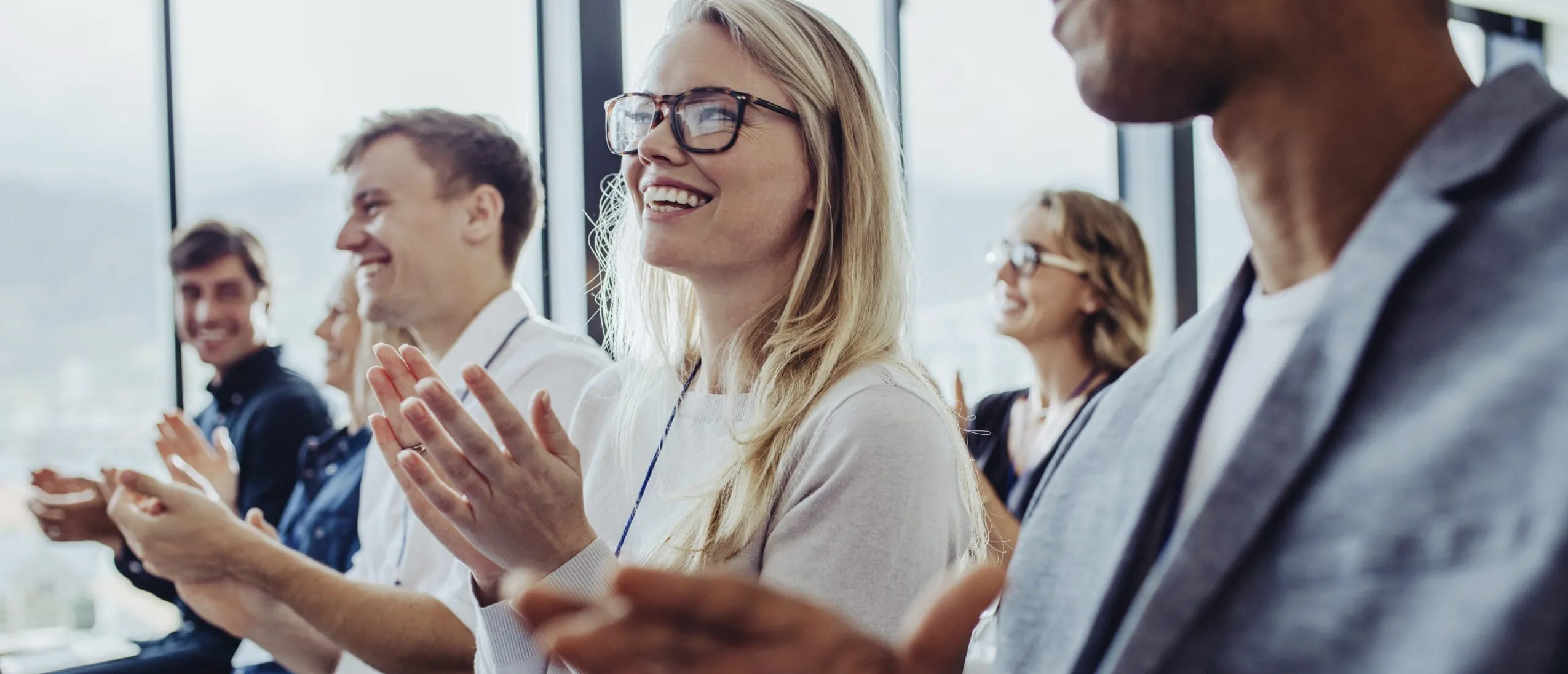 Ein Team von Geschäftsleuten klatscht während einer Tagung in einem Tagungshotel