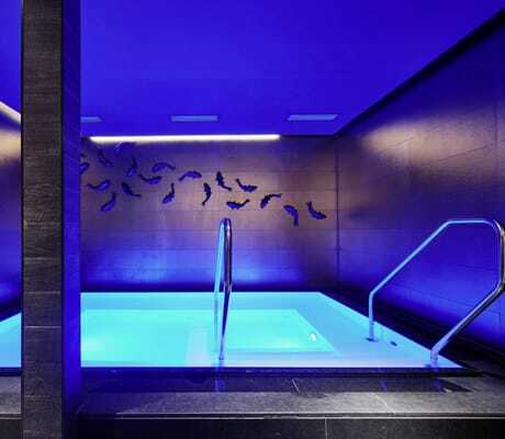 kleiner Indoorpool im Öschberghof mit Deko-Fischen an der Wand und blauem Licht