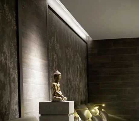 Detailaufnahme des Spabereiches im Öschberghof mit mehreren Ruheliegen mit Leselampen und dekorativer Buddha-Figur