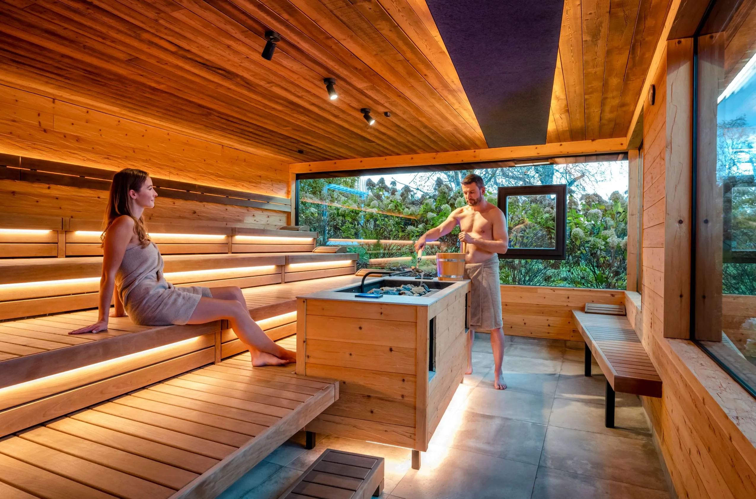 Gro&szlig;z&uuml;gige Sauna mit Ausblick nach drau&szlig;en ins saftige Gr&uuml;n.