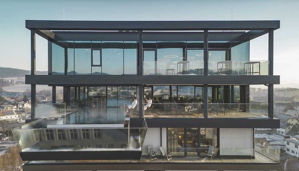 Paar in weißen Bademänteln schaukelt über dem Rooftoppool des DAS FREIGOLD