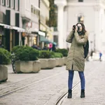 Junge Frau im Wintermantel fotografiert bei ihrem Städtetrip in München