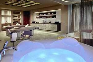 Spa-Suite für zwei Personen mit runder Ruheliege und blau beleuchtetem Whirlpool im Wellness- & Sporthotel Jagdhof
