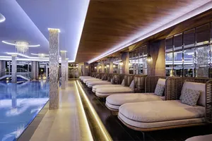 mit Rattan abgetrennte Ruhebereiche neben dem Indoorpool im Wellness- & Sporthotel Jagdhof