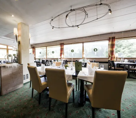 eingedeckte Tische im Restaurant des Waldhotel am Notschreipass mit gelben Hochlehner-Stühlen