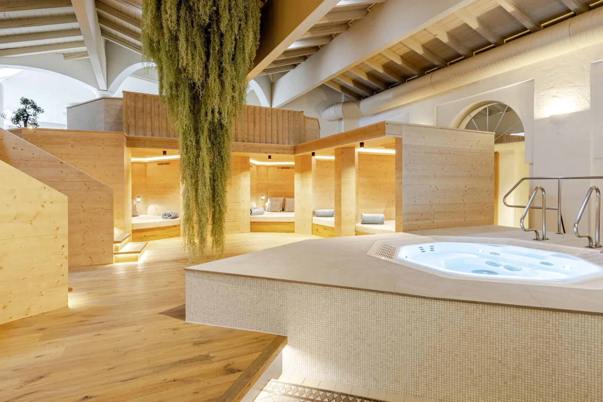 Whirlpool mit verschiedenen Ruheinseln separiert durch Holzw&auml;nde f&uuml;r mehr Privatsph&auml;re im Posthotel Achenkirch.
