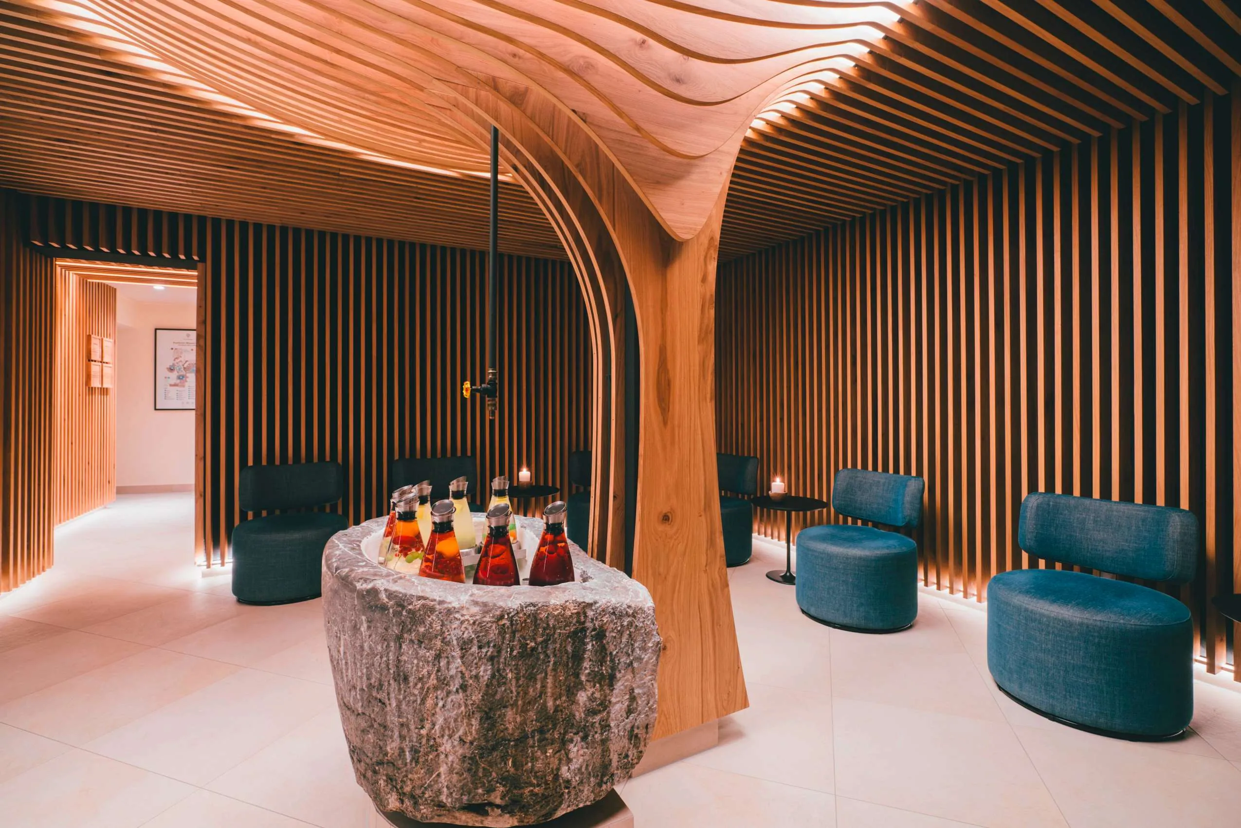 Modern designter Wellnessbereich mit dunkelblauen Polstersesseln und gek&uuml;hlten Getr&auml;nken im Posthotel Achenkirch