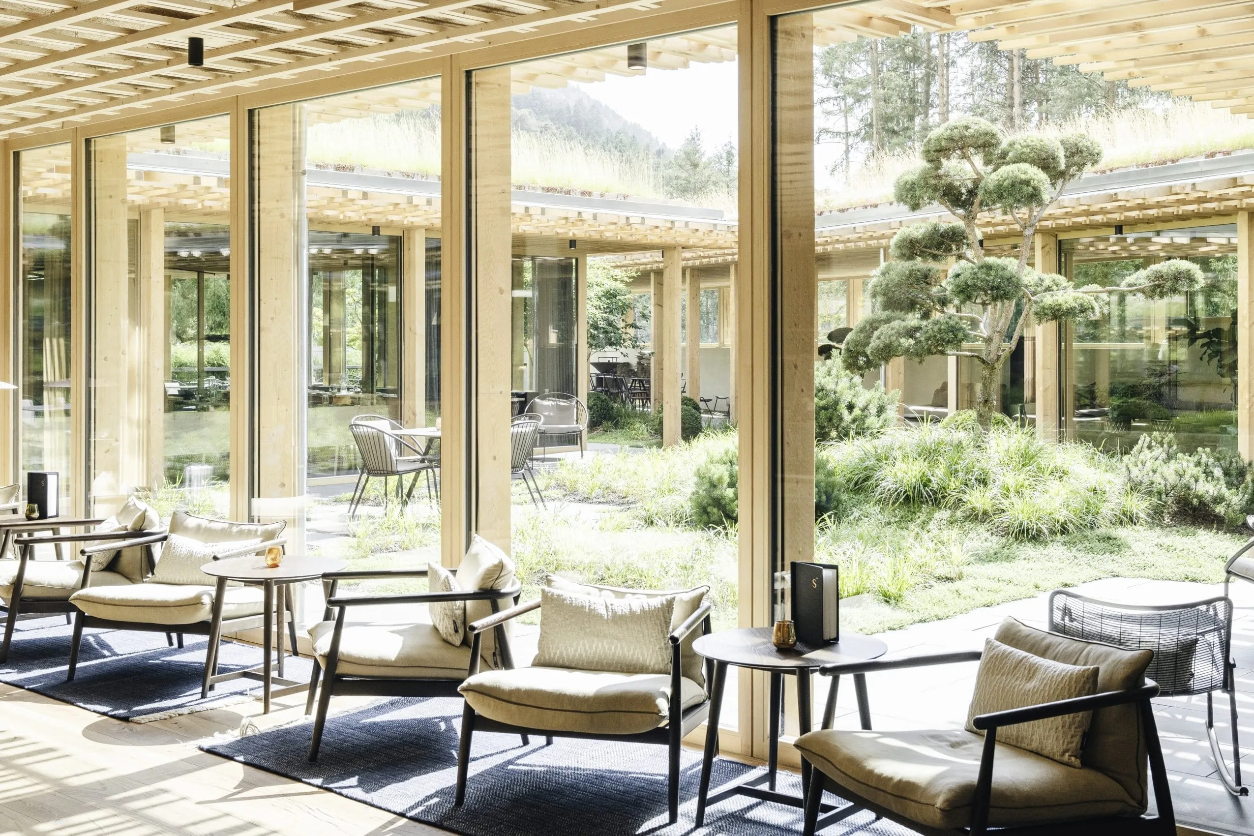 Lobby des Sensoria Dolomites in puristischer, nordischer Einrichtung mit Blick in den japanischen Garten im Innenhof