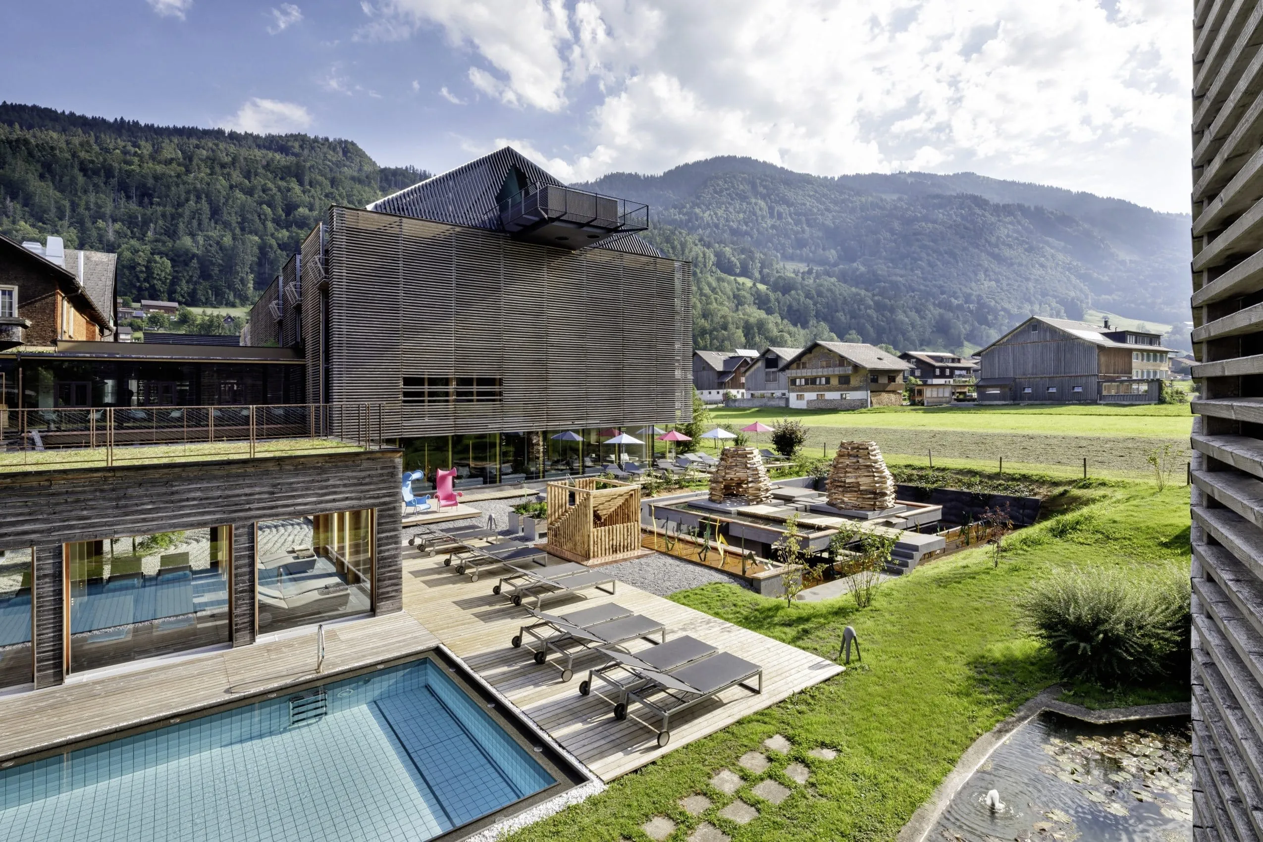 Außenansicht des GAMS zu zweit mit Outdoorpool, Sonnenliegen und grünen Wiesen