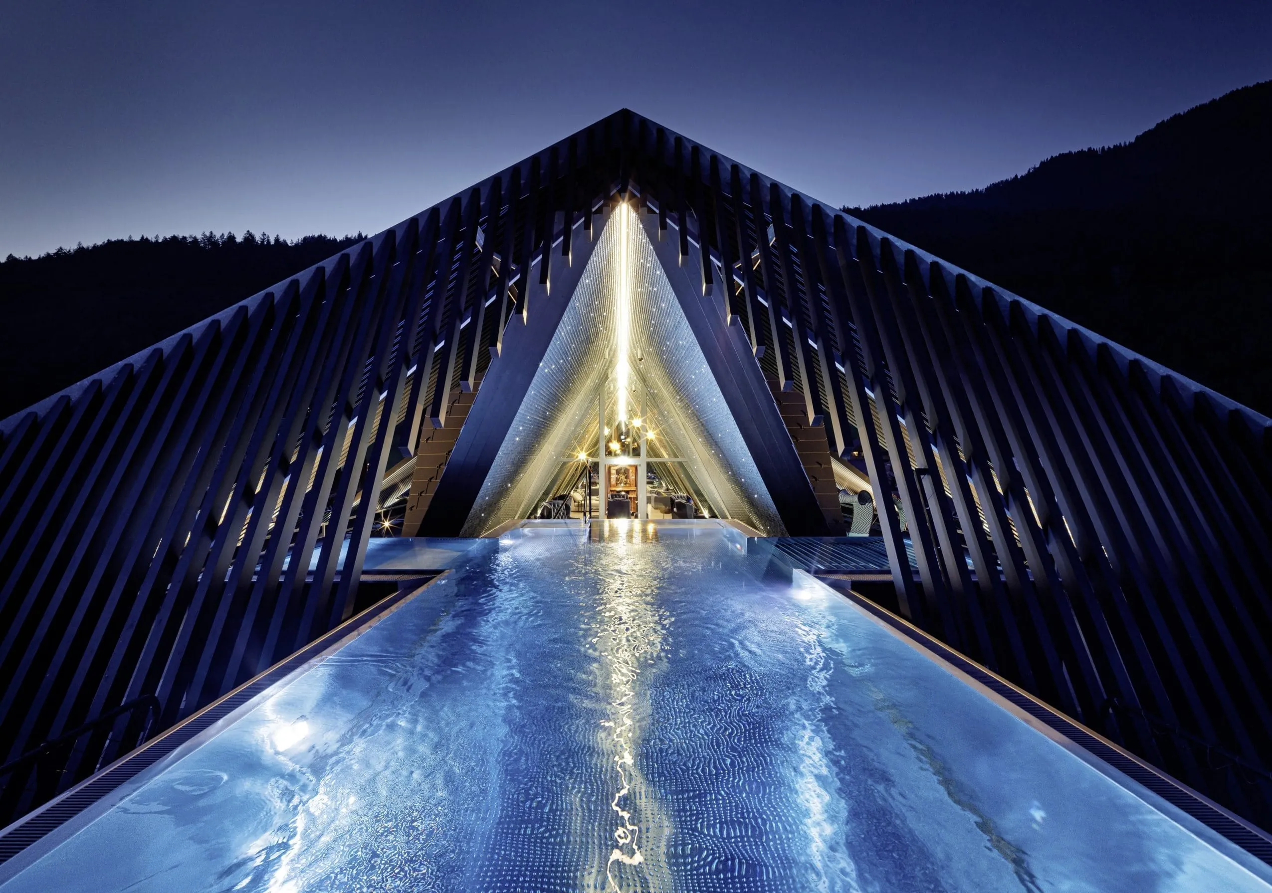 Blick auf den kunstvoll gestalteten, stimmungsvoll beleuchteten Outdoor-Pool Wolke 7 im Wellnesshotel GAMS zu zweit bei Dunkelheit