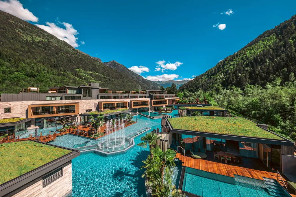 Außenansicht der Quellenhof See Lodge mit seinen verschiedenen Unterkünften und Pools in der Mitte