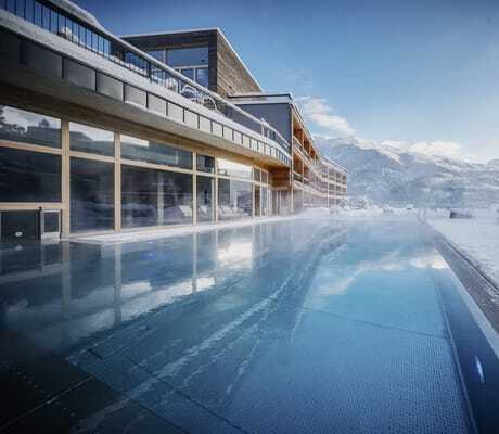 Outdoorpool des Das Kronthaler neben der Holzfassade im tiefen Winter