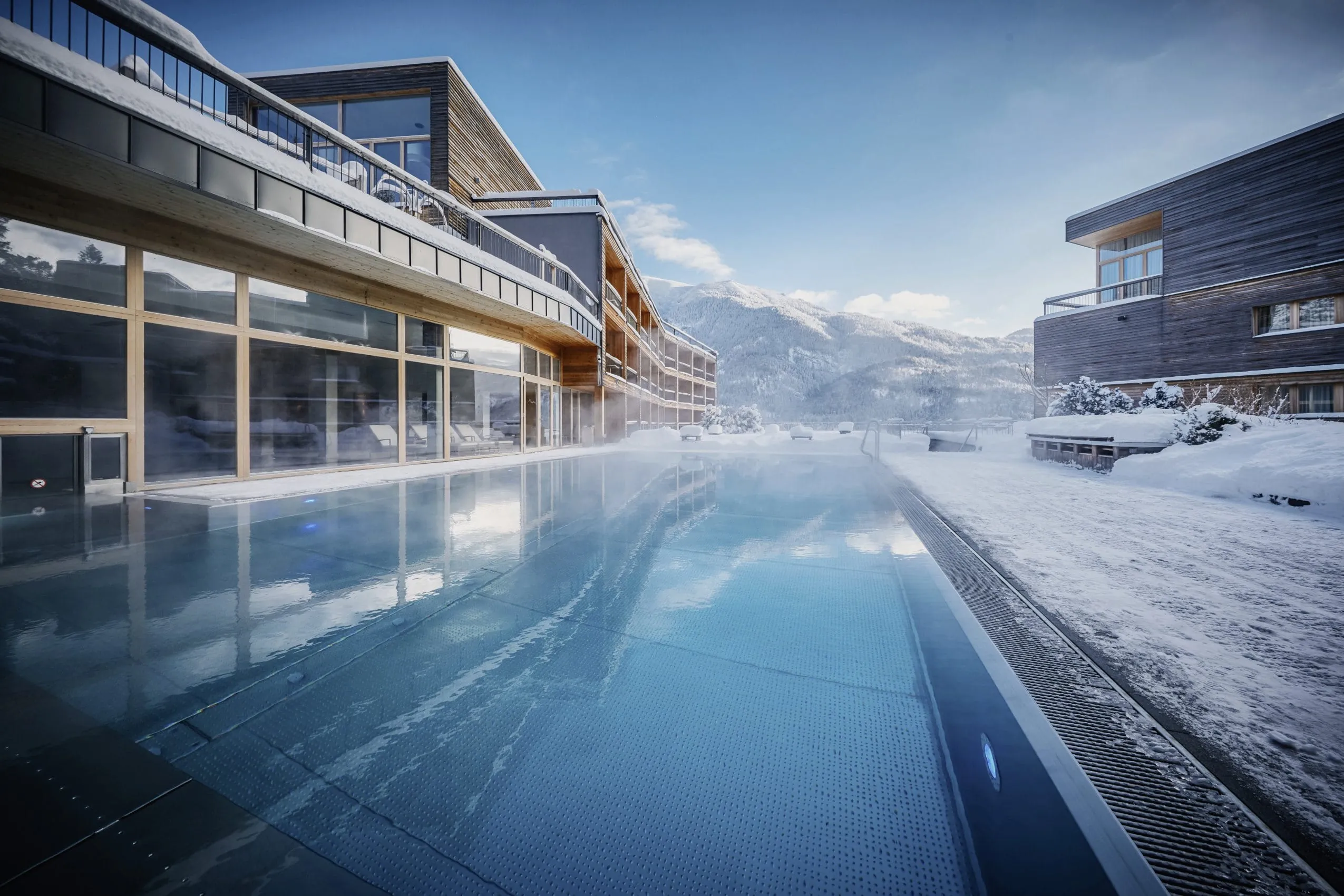 Outdoorpool des Das Kronthaler neben der Holzfassade im tiefen Winter
