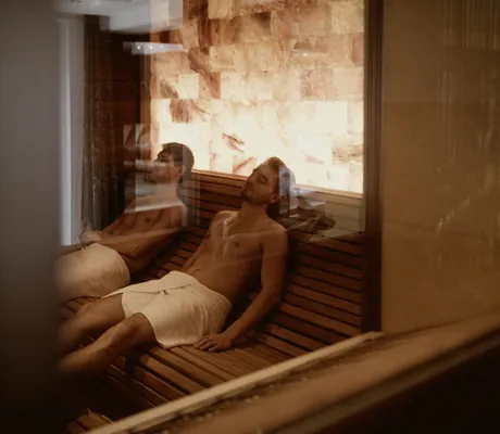 zwei Männer liegen mit Handtüchern auf der Liege im Salzraum des Das Kronthaler