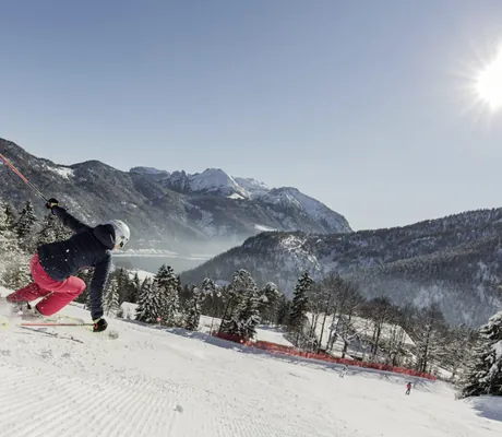 Skifahrerin mit roter Skihose saust Skiberg neben dem Das Kronthaler bei Sonnenschein hinunter