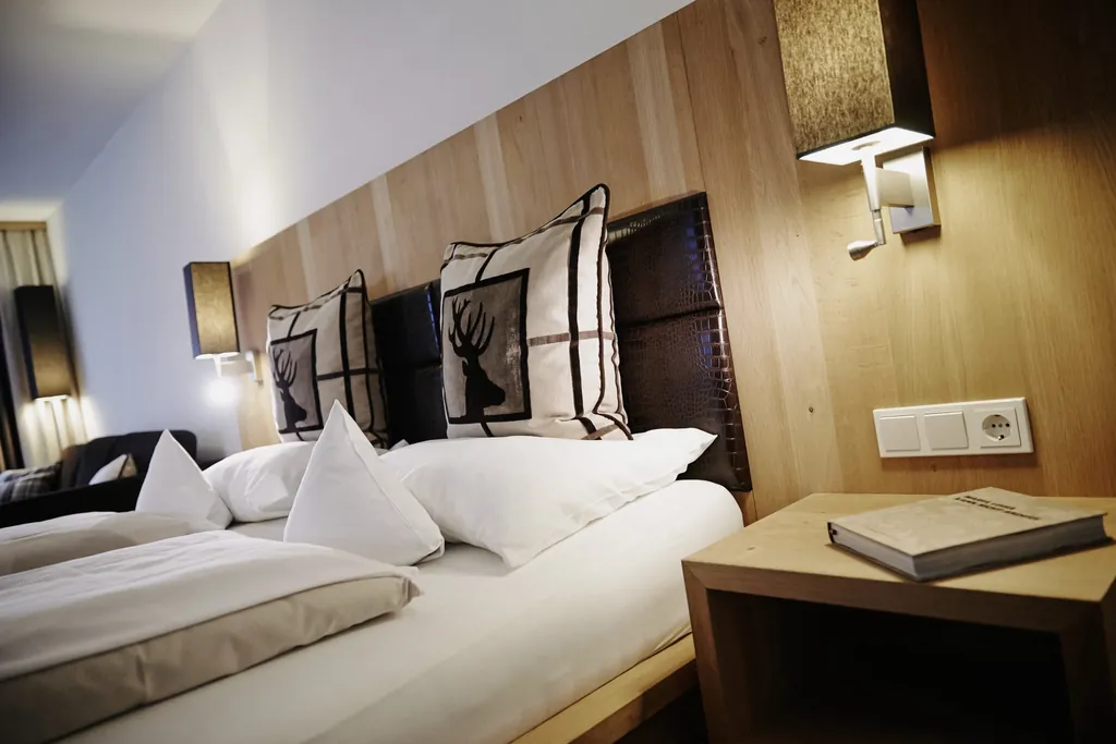 Doppelbett im Zimmer des Das Kronthaler mit Hirschdruck auf den Kissen