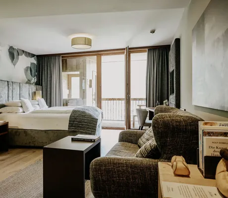 Suite im Das Kronthaler mit geblümter Bettenrückwand Blick auf die eigene Balkon-Sauna