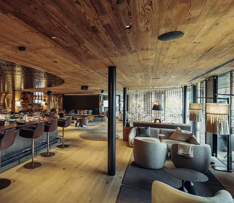 Bar und Lounge mit dunkler Holzdecke und Stehlampen im Hotel Jungbrunn
