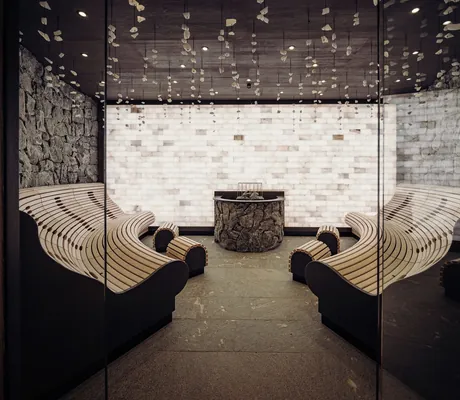 Salzinfrarotraum im Hotel Jungbrunn mit Salzsteinwand und runden Holzliegen