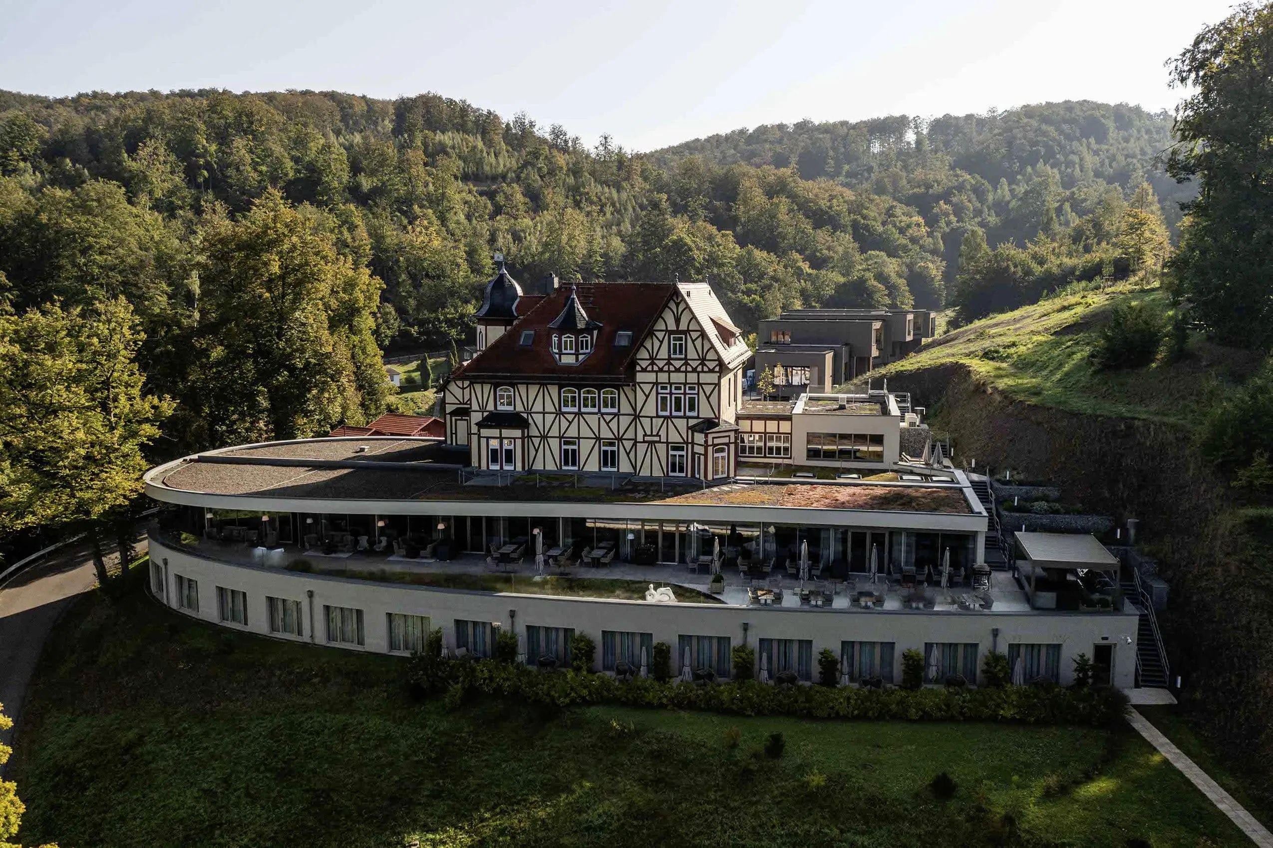 Blick aus der Luft auf das Adults only Hotel & Spa Suiten FreiWerk mit historischer Fachwerksvilla im Zentrum und umgeben vom Südharzer Wald