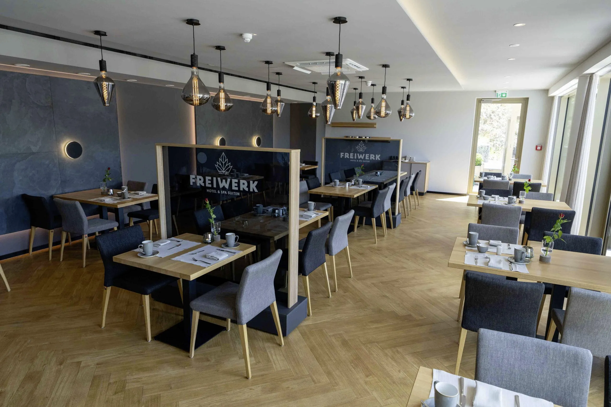Restaurant im Hotel & Spa Suiten FreiWerk mit eingedeckten Tischen und moderner Einrichtung