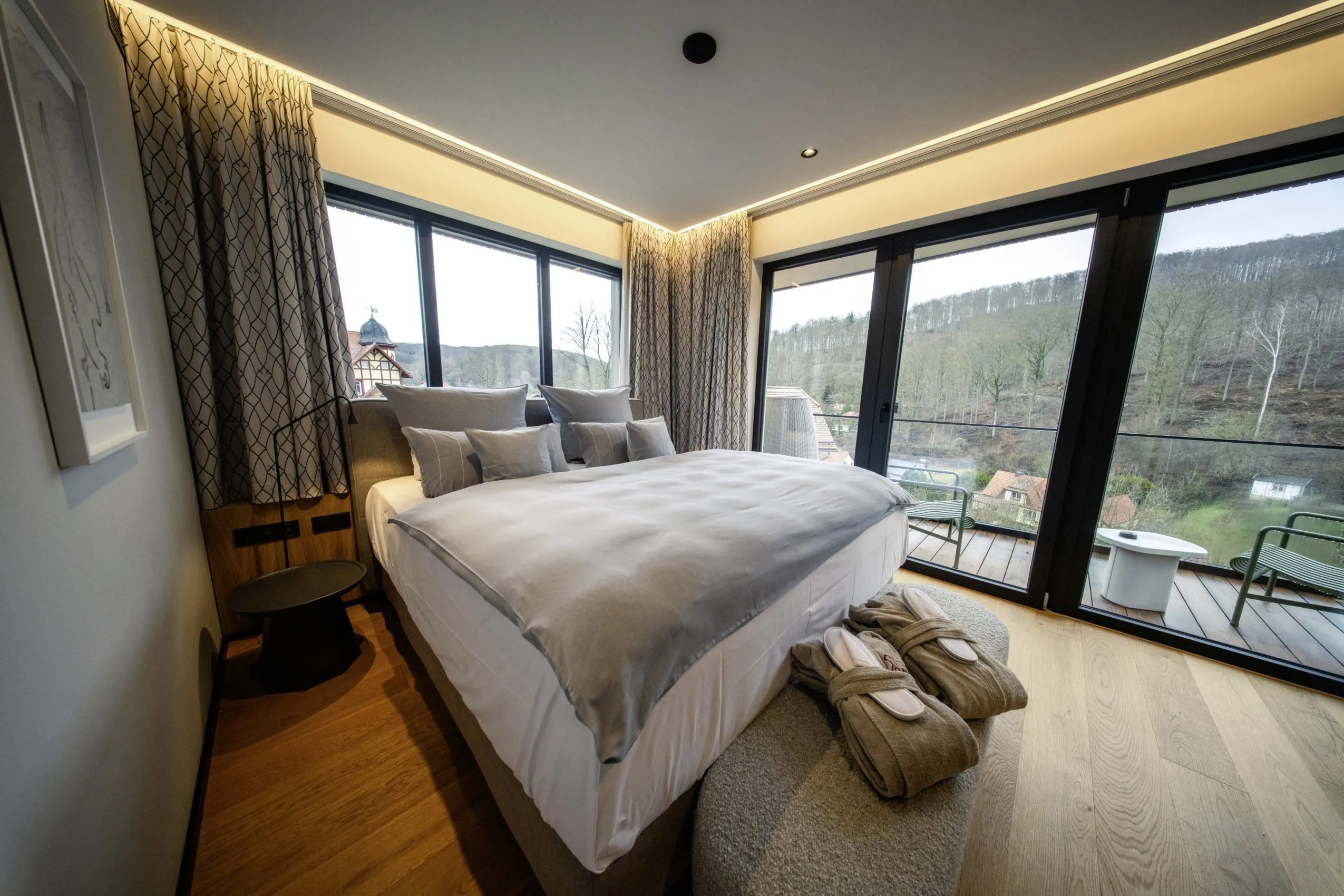 Schlafzimmer mit Doppelbett, Balkon und bodentiefen Fenstern mit Blick Richtung Wald im Hotel & Spa Suiten FreiWerk