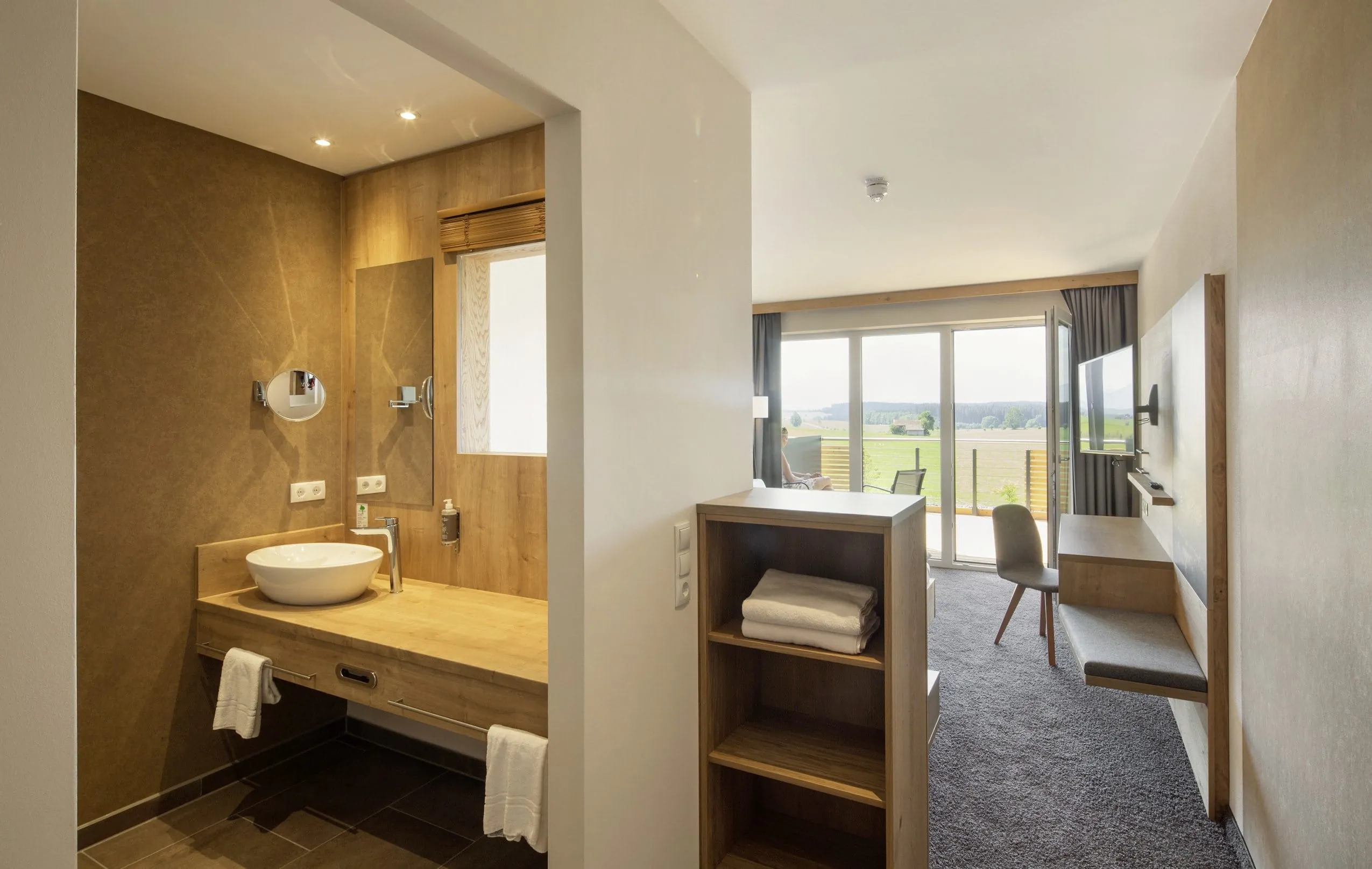 Blick in ein Doppelzimmer mit offenem Badezimmer und Balkon Richtung S&uuml;den im Tagungshotel in Bayern