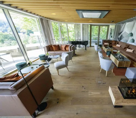 Lounge mit Kamin und terrakottafarbenen Sitzecken im Hotel FreiWerk