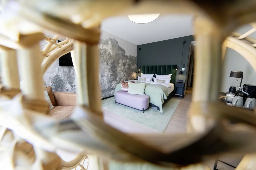 Blick auf das Bett in der Suite des Hotel FreiWerk mit schwarz/weiß-Foto von alter Burg