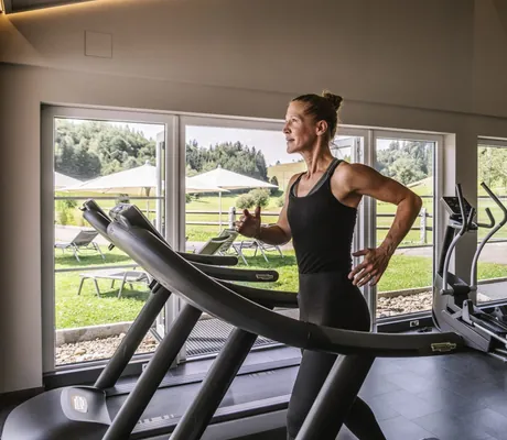 durchtrainierte Frau auf Laufband im Fitnessraum von Haubers Naturresort
